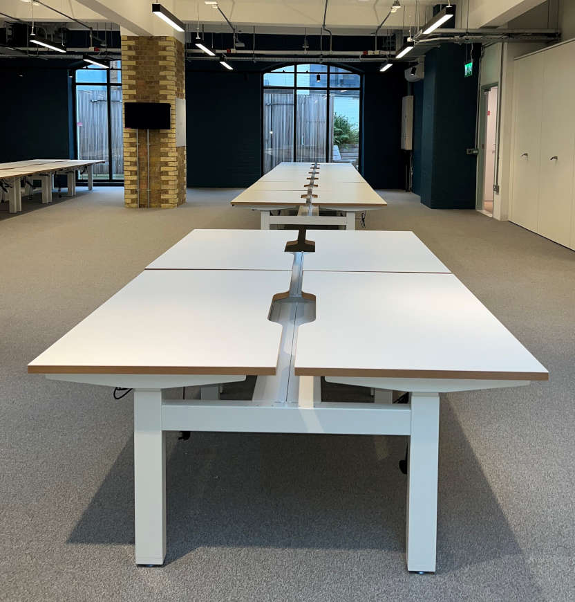 Matching second-hand commercial office desks arranged in an open-plan workplace.